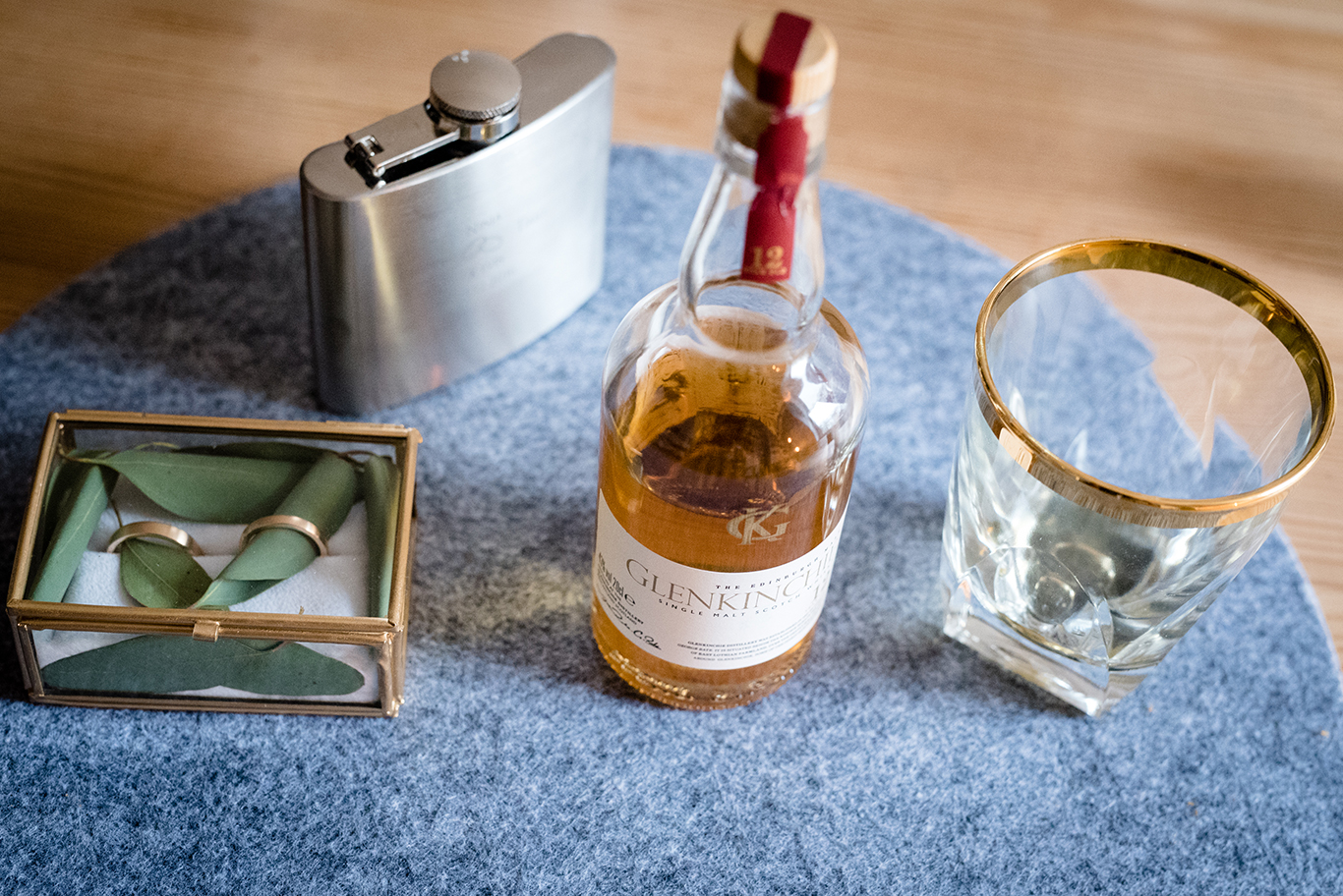 Flachmann, Whiskeyflasche und Eheringe liegen bereit vor der Trauung