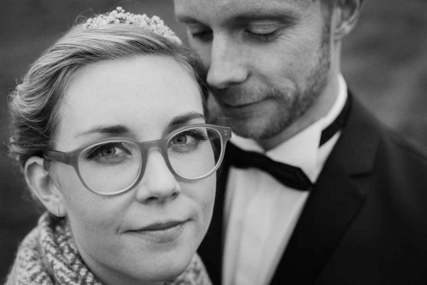 Braut mit Diadem lehnt den Kopf an den Bräutigam, Schwarzweißaufnahme