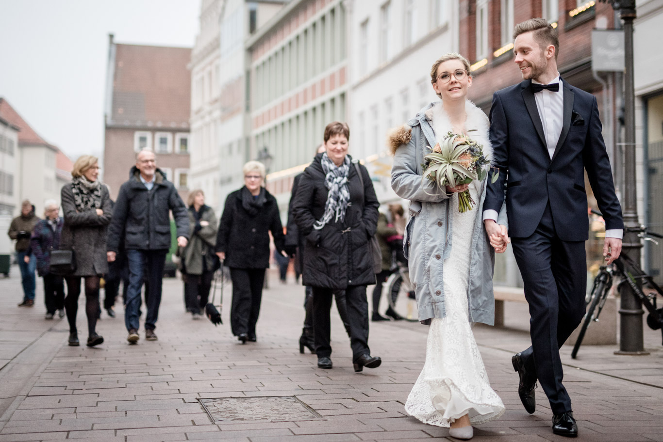 Gäste begleiten das Brautpaar durch die winterliche Altstadt