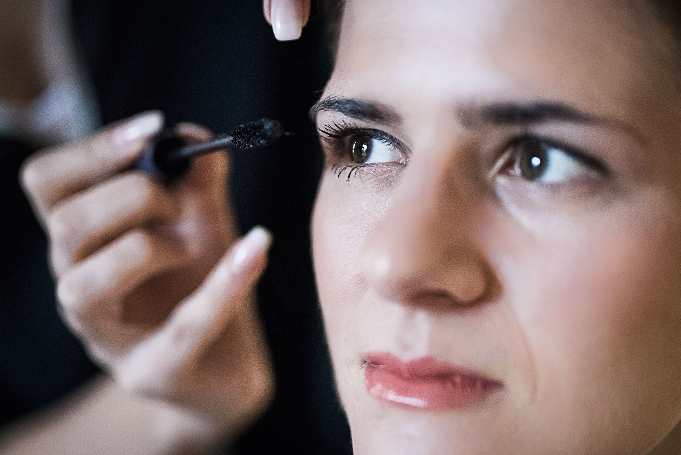Braut schminkt sich selbst konzentriert die Augen