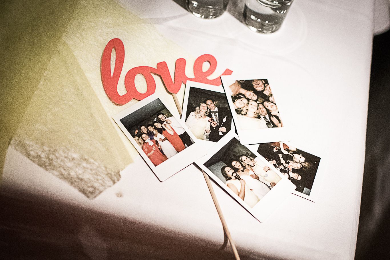 Sofortbildfotos mit Schriftzug „love” liegen auf dem Tisch