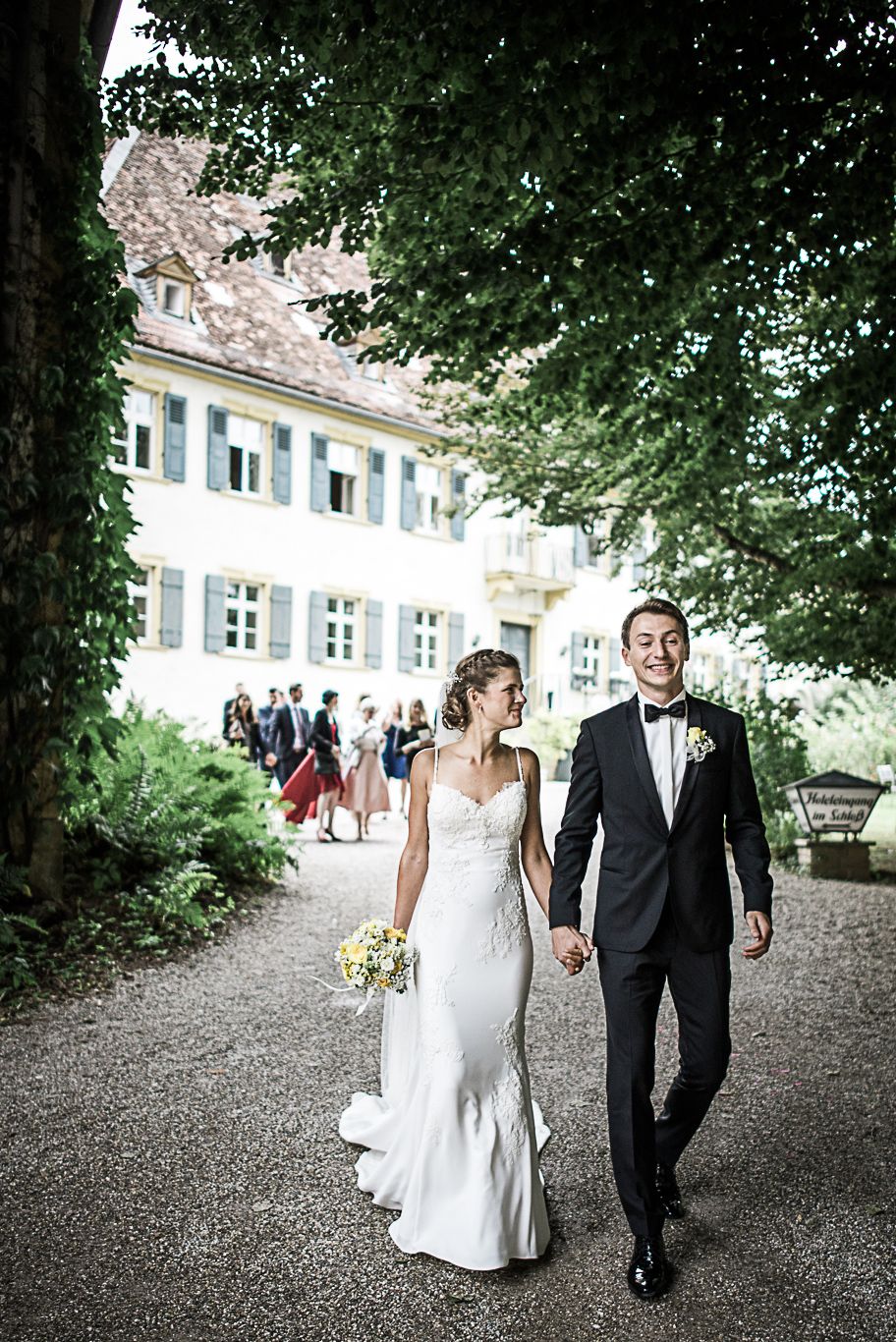 Brautpaar geht Hand in Hand durch den Park von Schloss Heinsheim