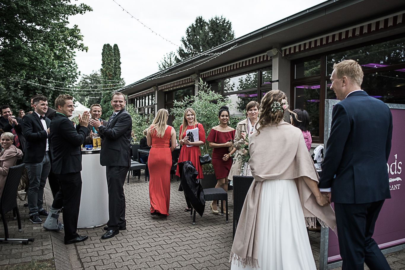 Gäste unterhalten sich stehend auf der Terrasse vor dem Restaurant Moods