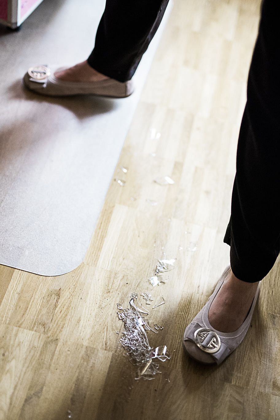 Braut steht in Ballerinas auf zerknülltem Papier am Boden