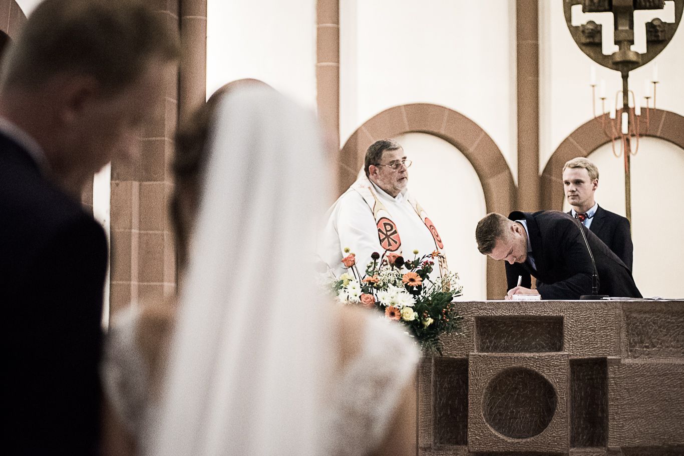 Braut unterschreibt die Traudokumente am Altar