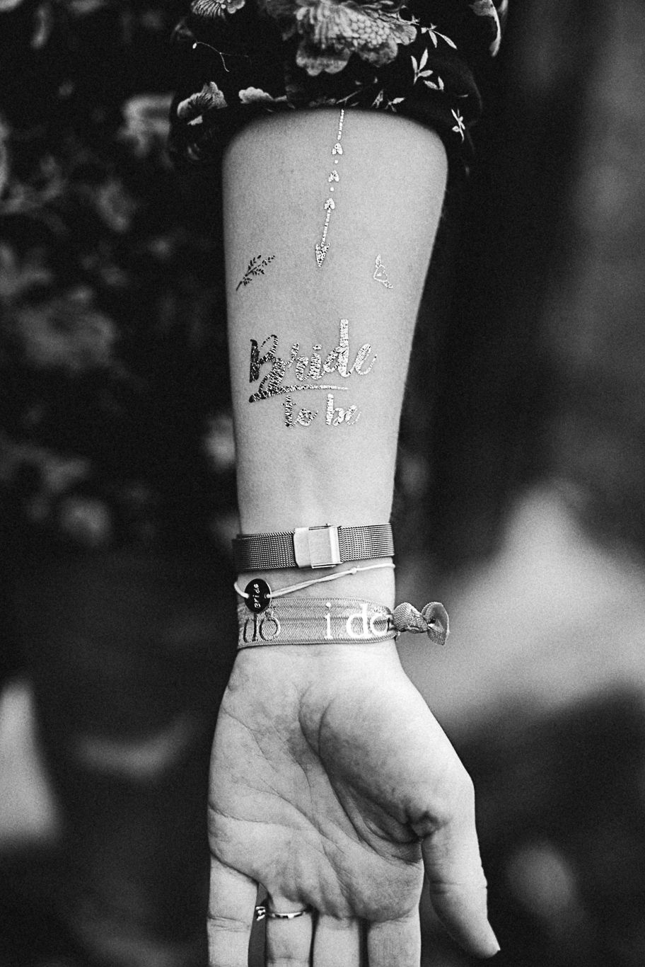 Nahaufnahme eines Schriftzug-Armbands am Handgelenk einer Frau