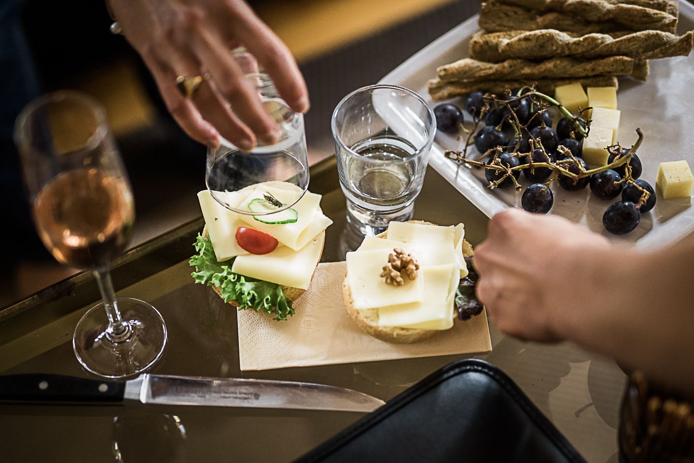 Hände richten Käseplatte mit Sekt für die Gäste an
