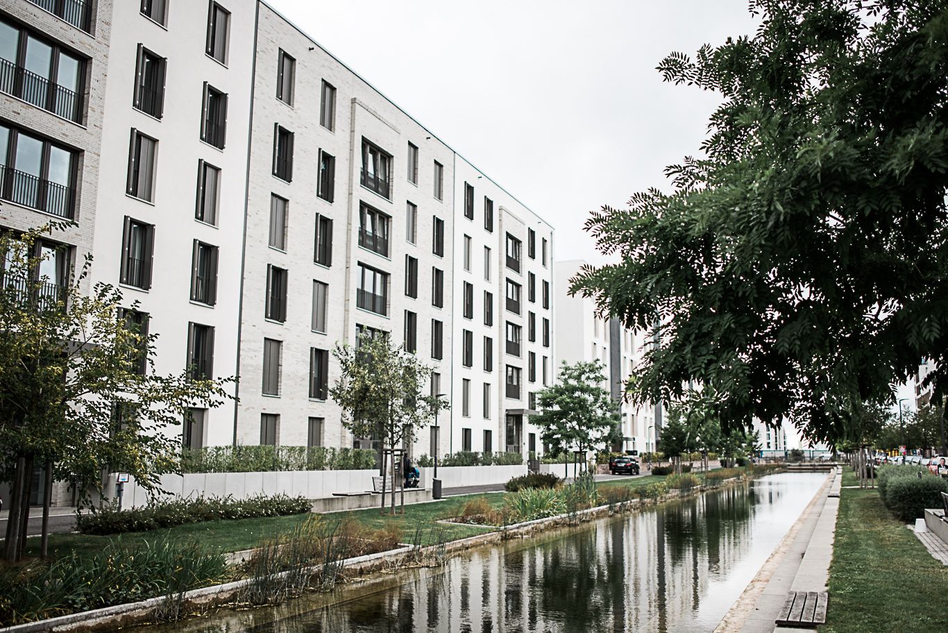 Moderne Wohnhäuser spiegeln sich in einem Kanal