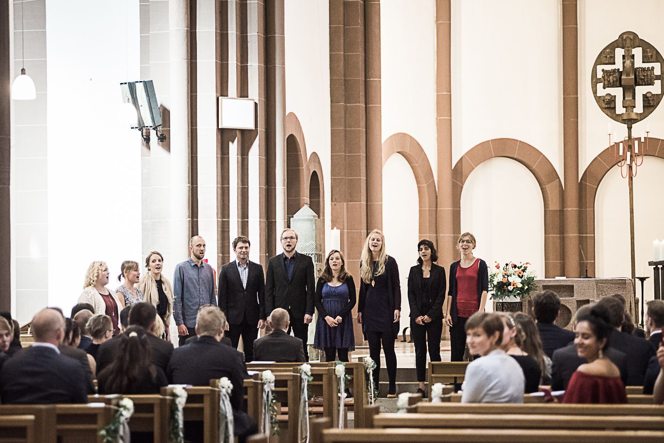 Gäste sitzen in der Kirchenbank während der Trauung