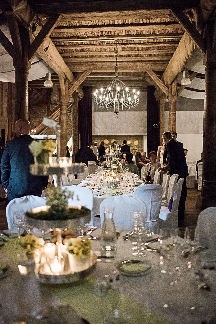 Festlich gedeckte Tafel in einem rustikalen Saal mit Kronleuchtern auf Schloss Heinsheim