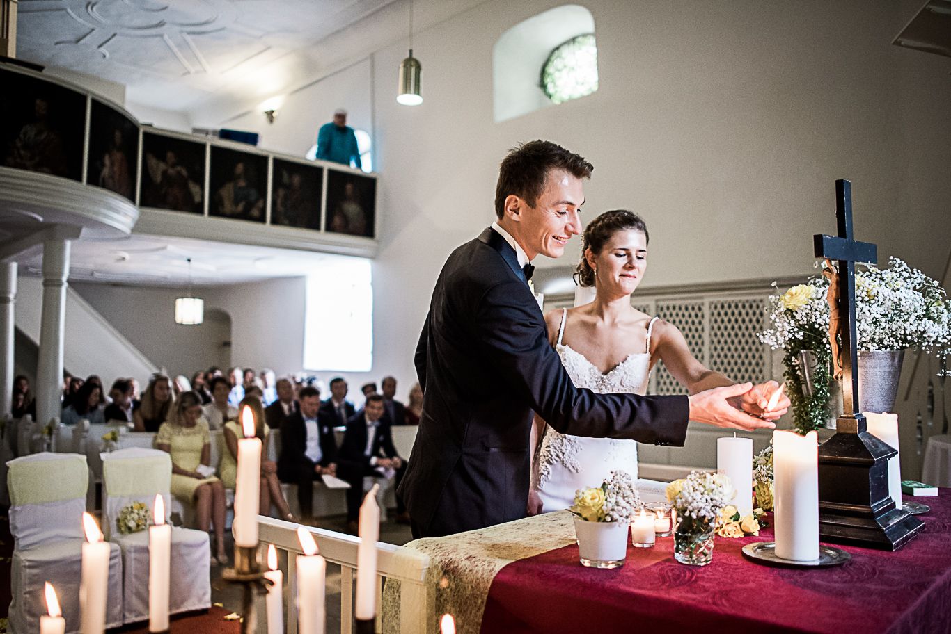 Brautpaar zündet gemeinsam eine Kerze am Altar an