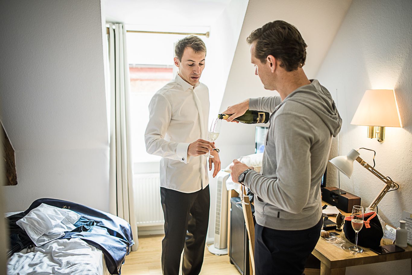 Zwei Männer stehen im Zimmer und sprechen miteinander, Schwarzweißaufnahme