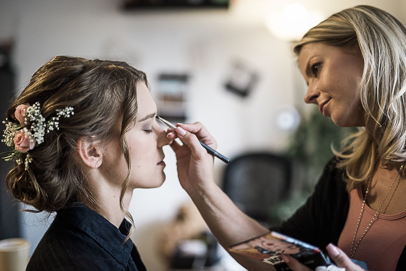 Visagistin schminkt die Augen der Braut, Schwarzweißaufnahme