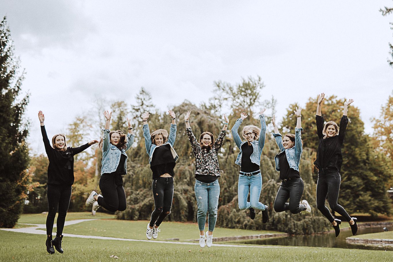 Gruppe Frauen springt jubelnd in die Luft im Park