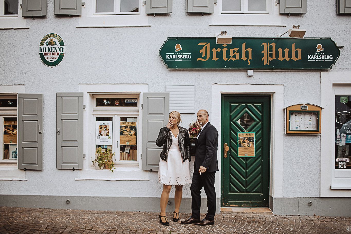 Freunde des Brautpaars stehen lachend vor einem Irish Pub