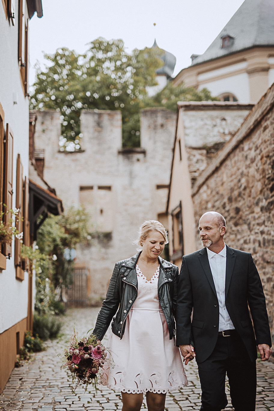 Brautpaar geht Hand in Hand durch eine Altstadtgasse in Speyer