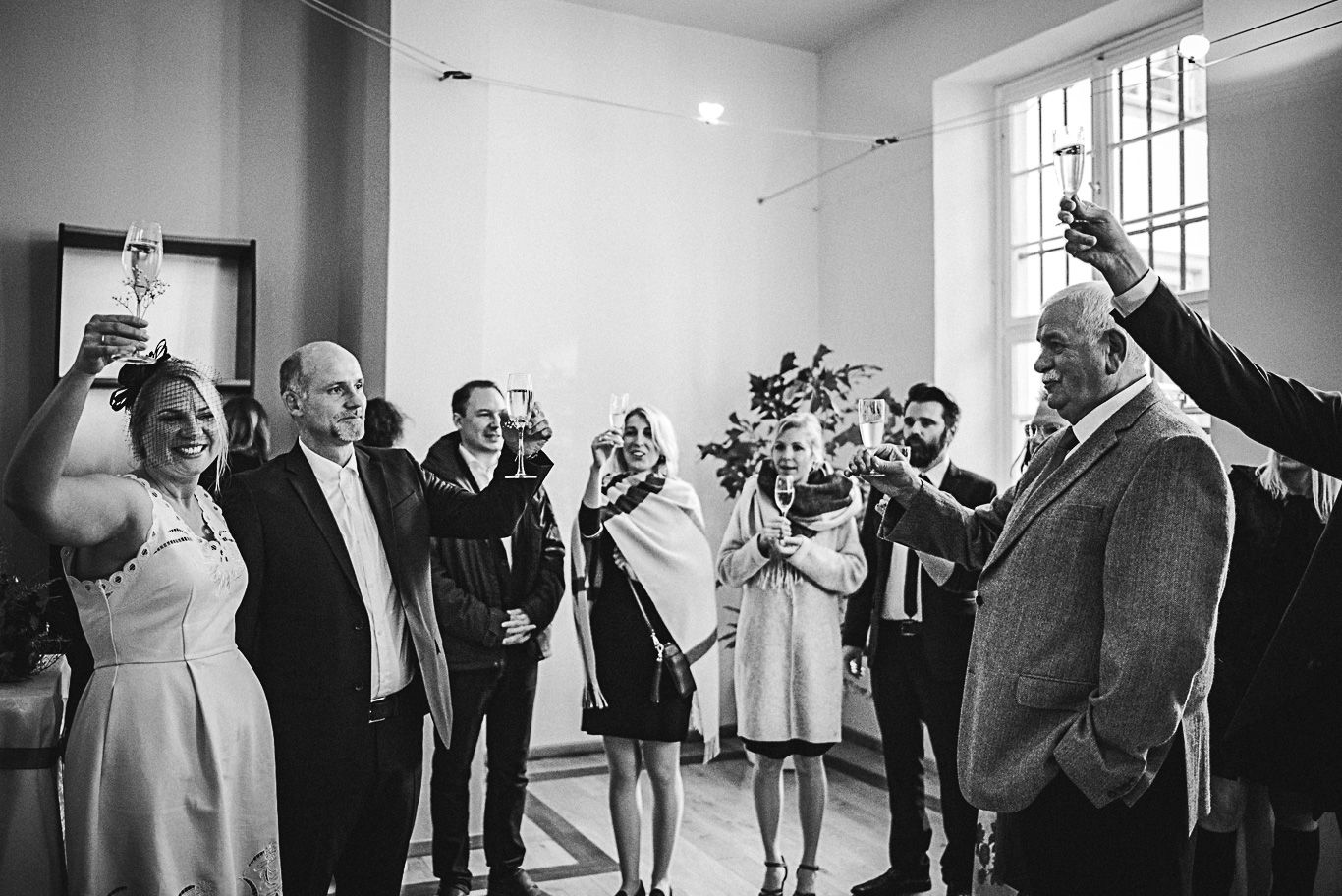Gäste stoßen lachend mit Sektgläsern an, Schwarzweißaufnahme