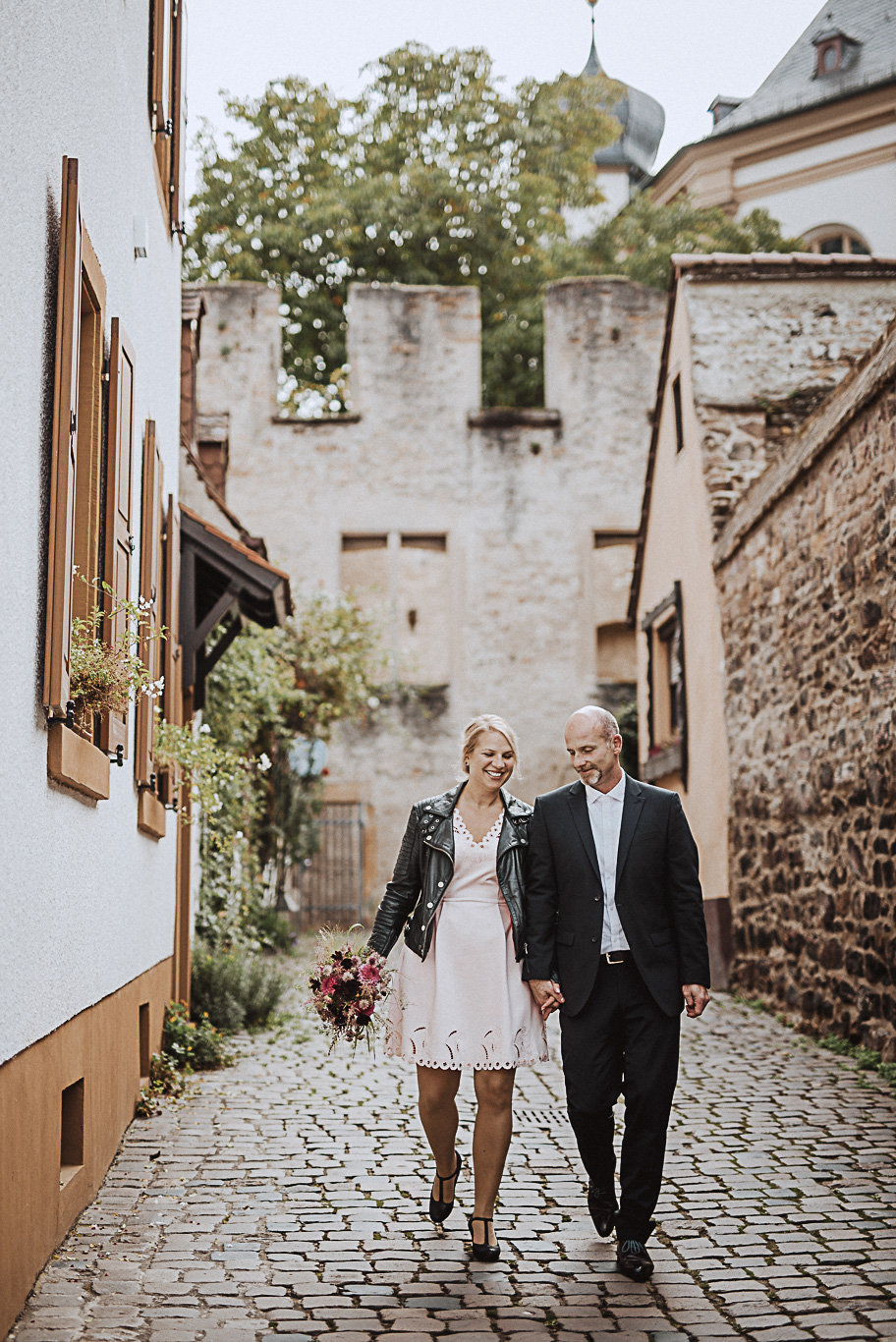 Brautpaar geht Hand in Hand durch eine historische Gasse in Speyer