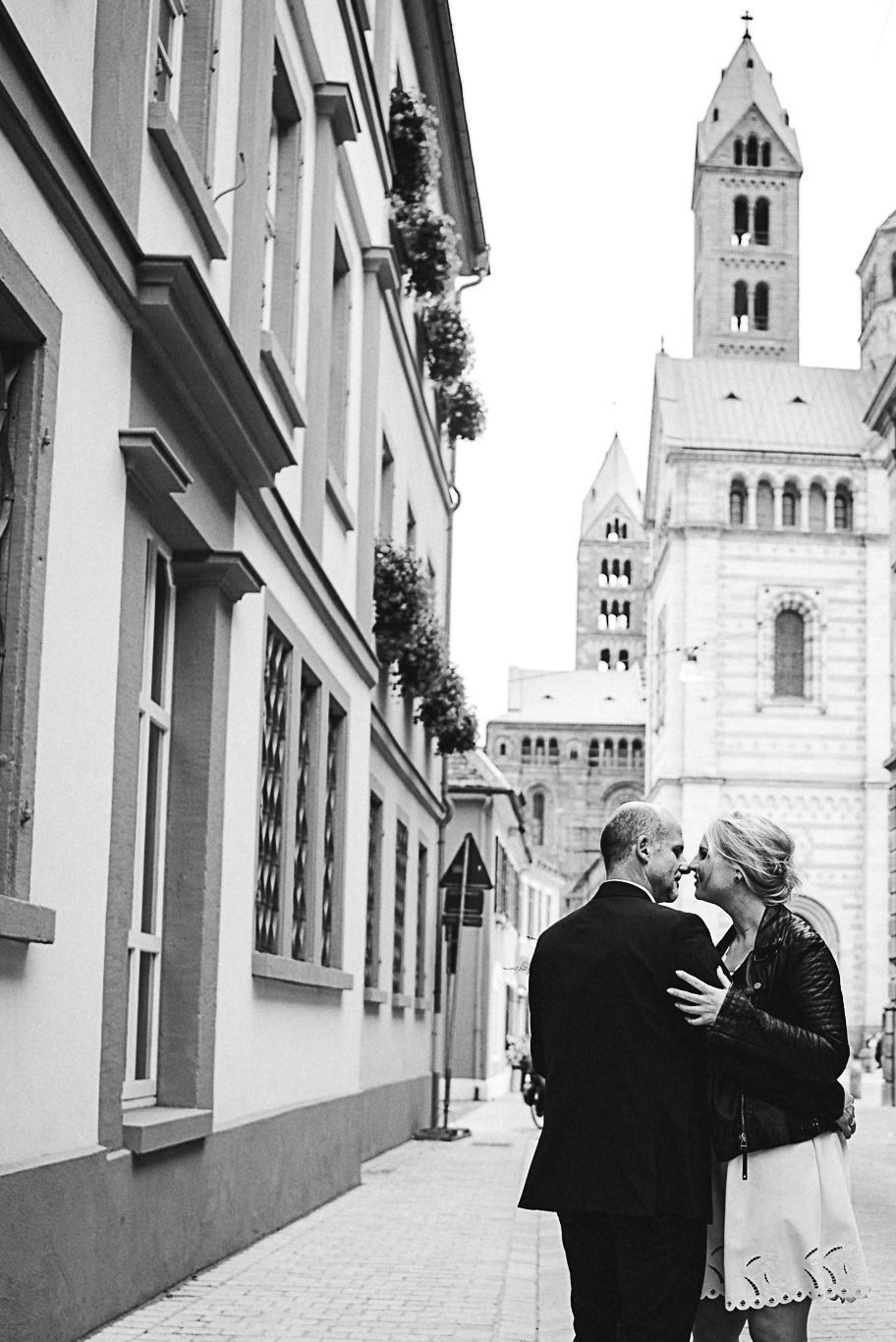 Bräutigam küsst Braut vor dem Speyerer Dom, Schwarzweißaufnahme