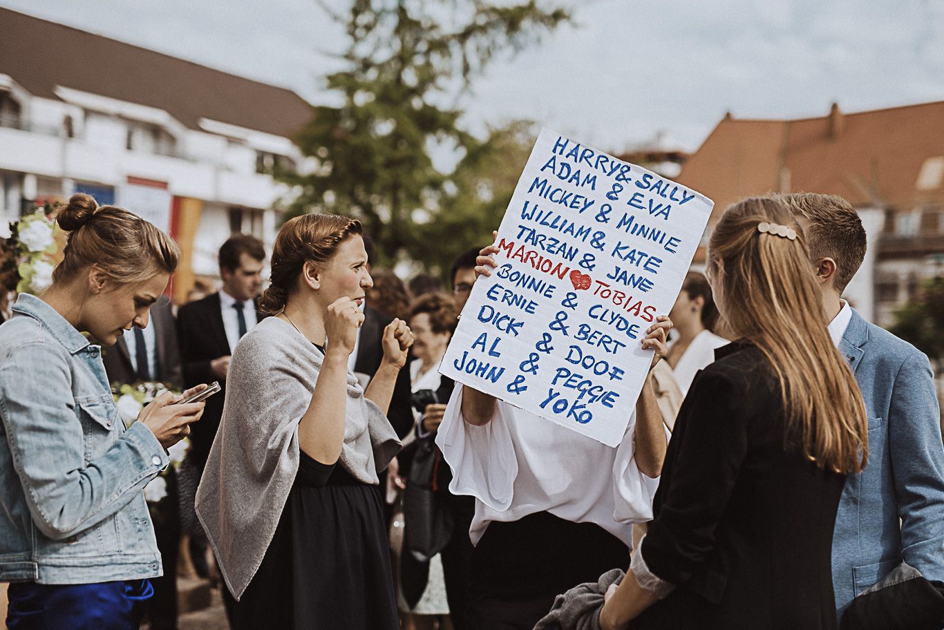 Gäste halten ein handgeschriebenes Schild mit Glückwünschen hoch