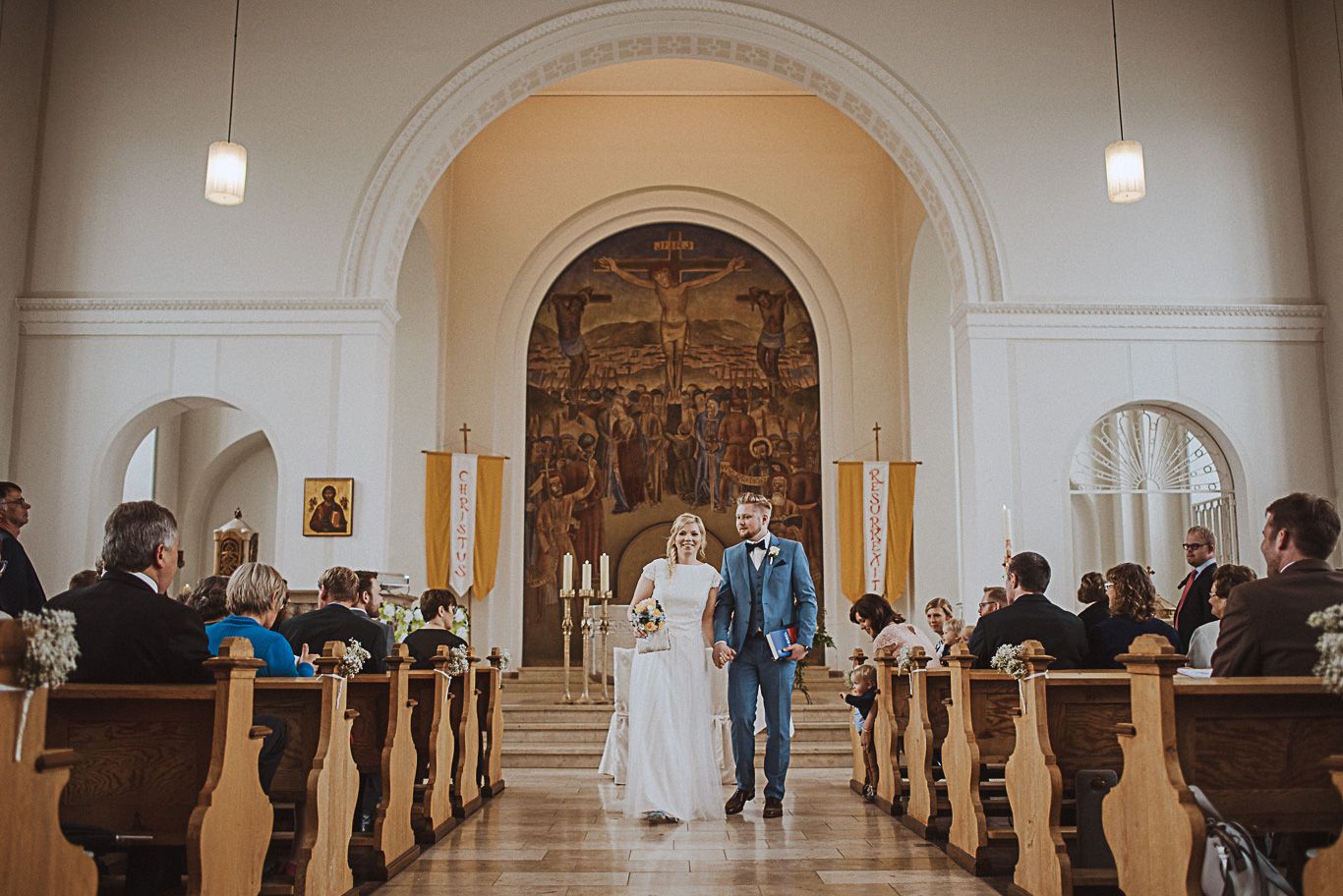 Bräutigam geht mit Braut durch den Mittelgang der Kirche