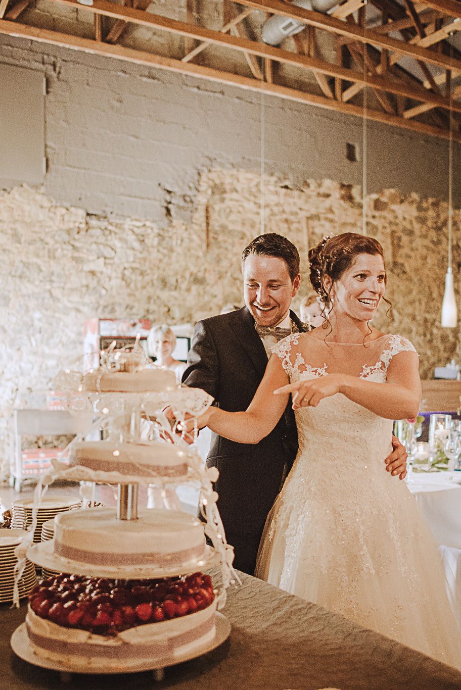 Brautpaar schneidet gemeinsam die Hochzeitstorte an