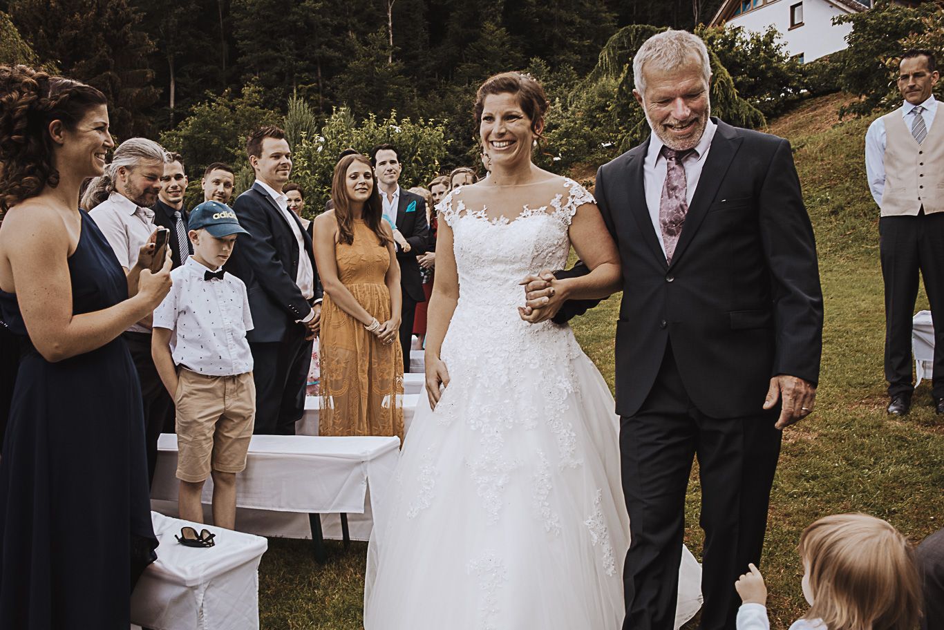 Vater führt die Braut zum Altar im Garten