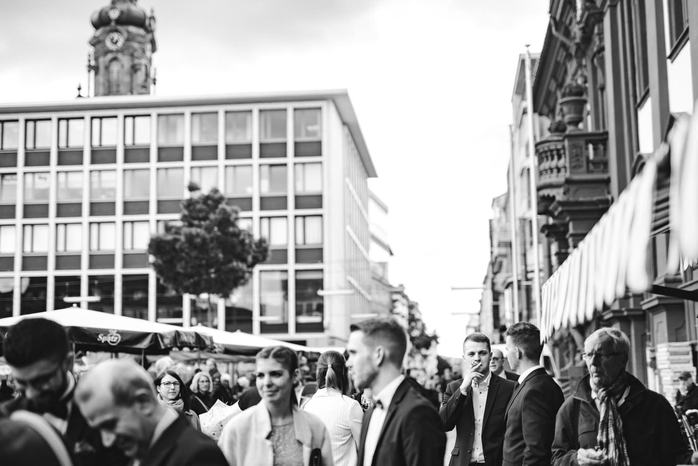 Gäste stehen in einer belebten Einkaufsstraße in Mannheim, Schwarzweißaufnahme