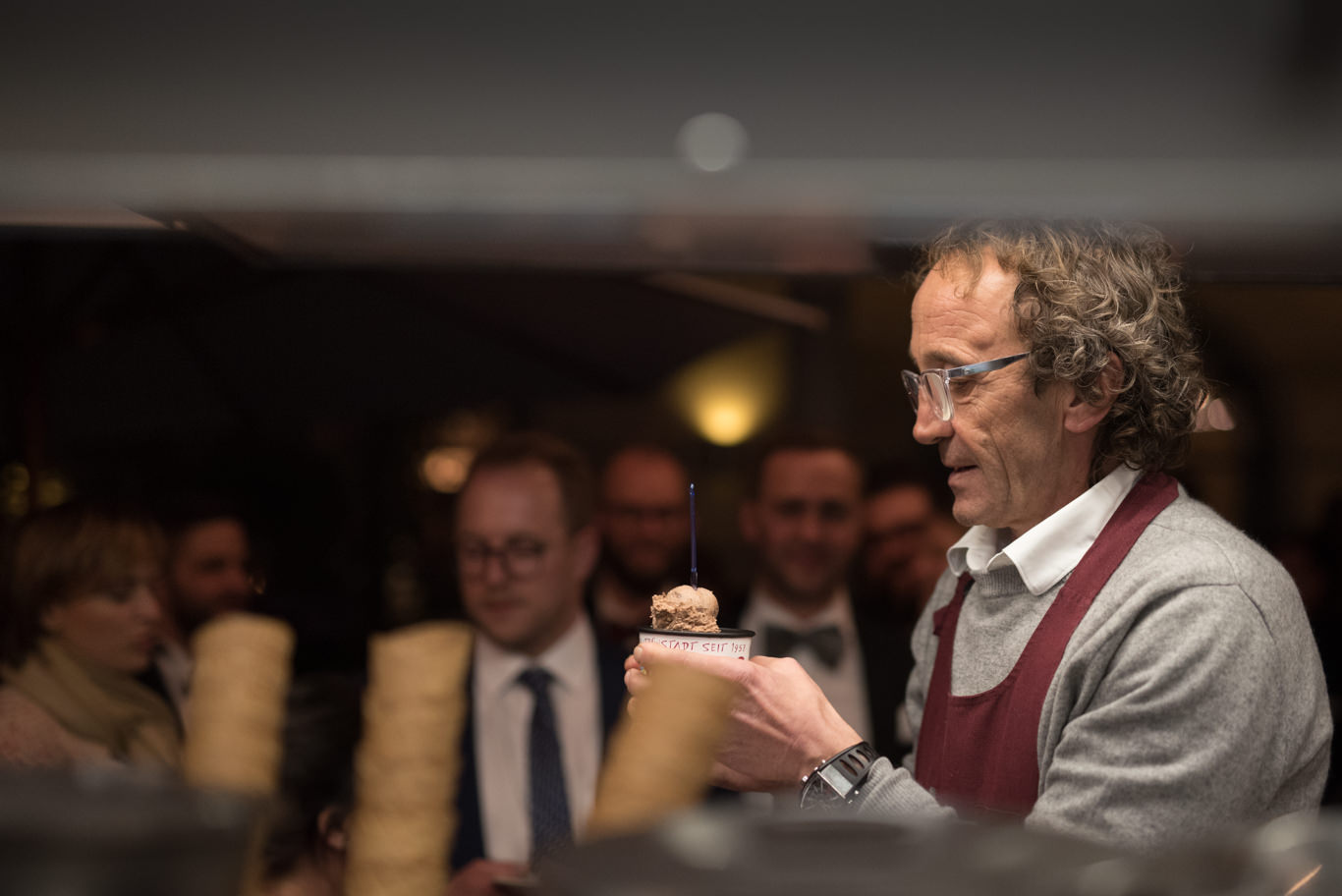 Mann schneidet lächelnd die Hochzeitstorte an