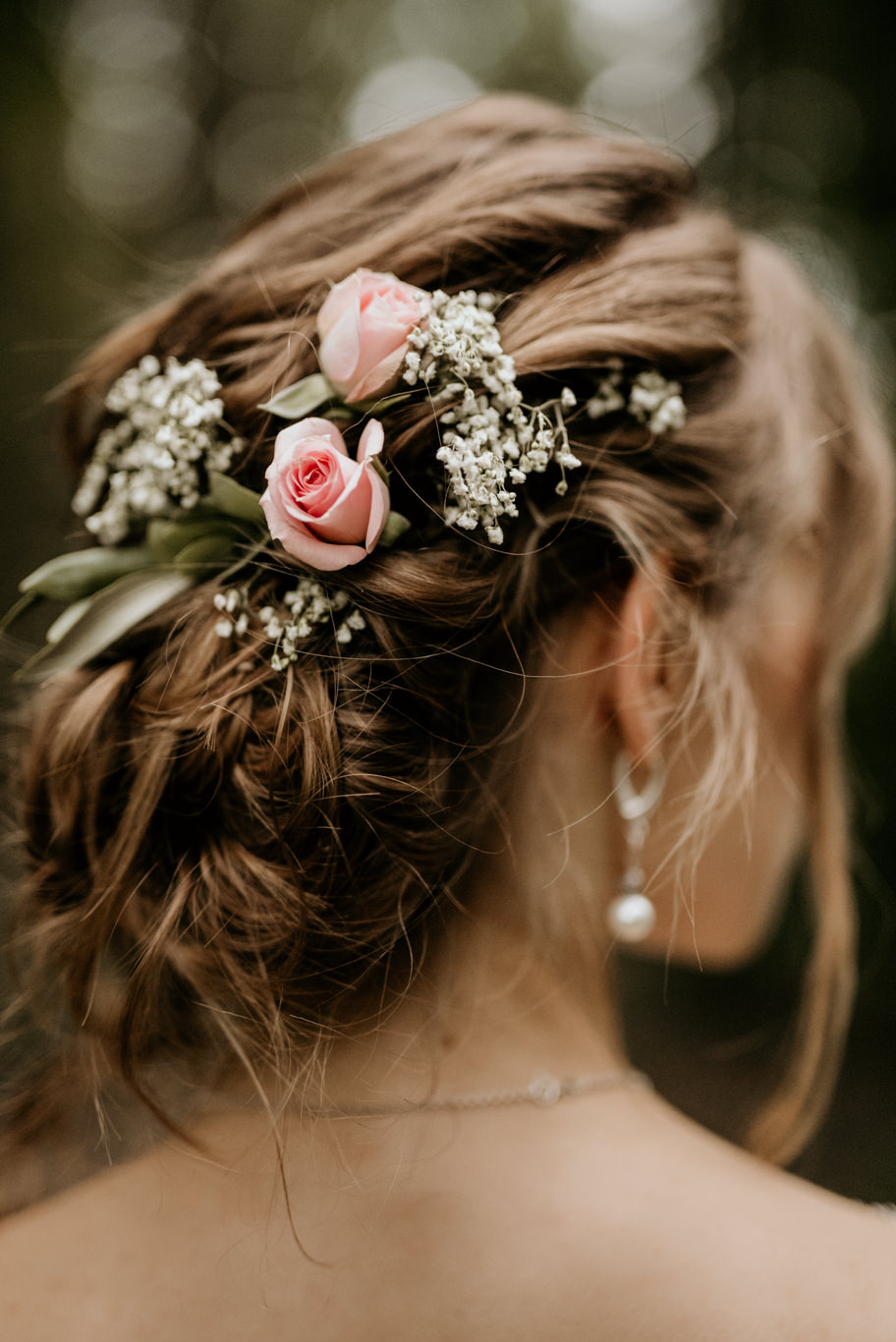 Nahaufnahme von Blumen im hochgesteckten Haar der Braut