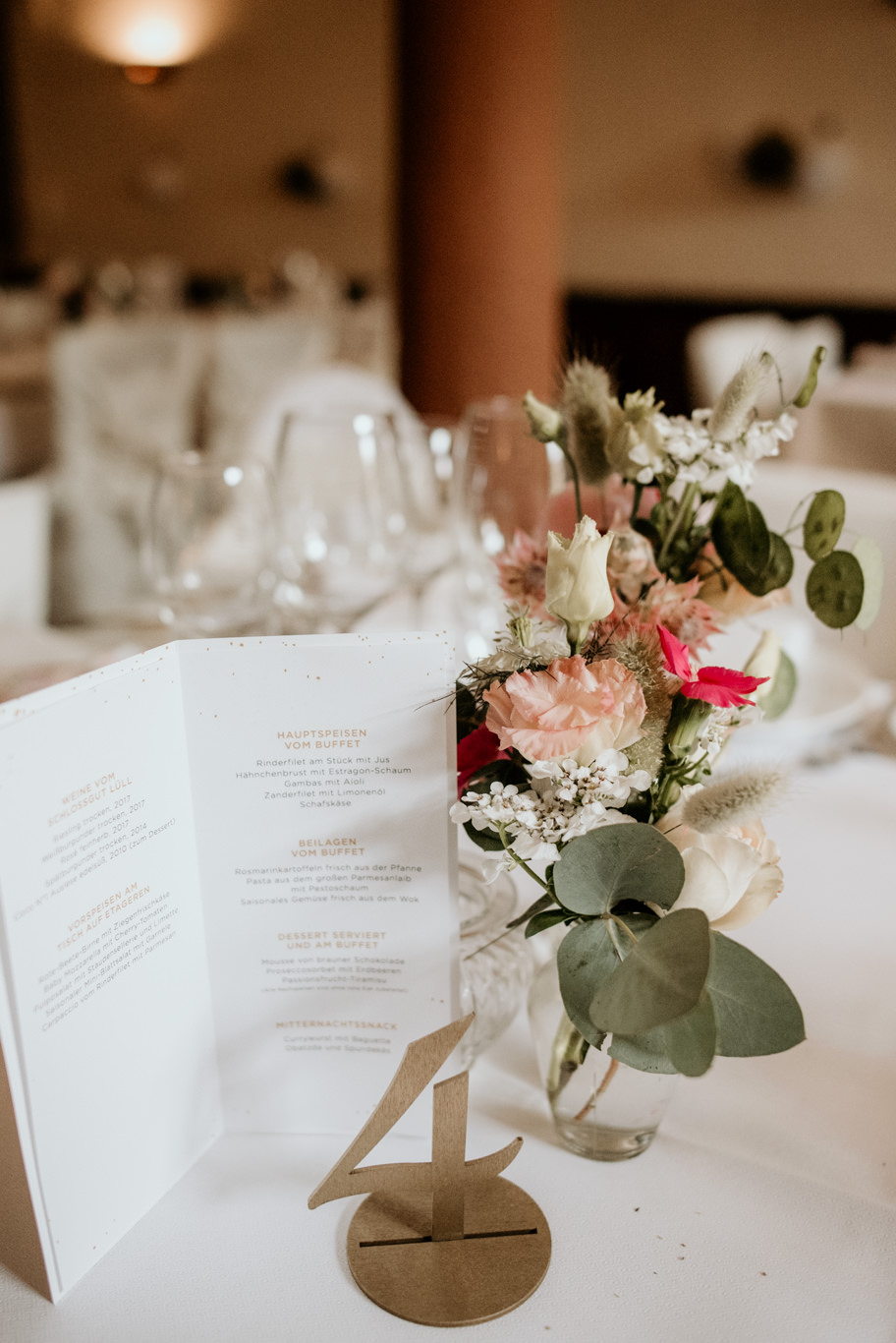 Tischkarte mit Blumenstrauß steht auf der festlich gedeckten Tafel
