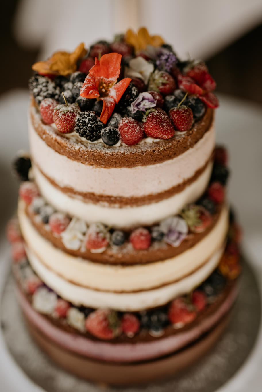 Naked Cake mit frischen Beeren und Blüten dekoriert