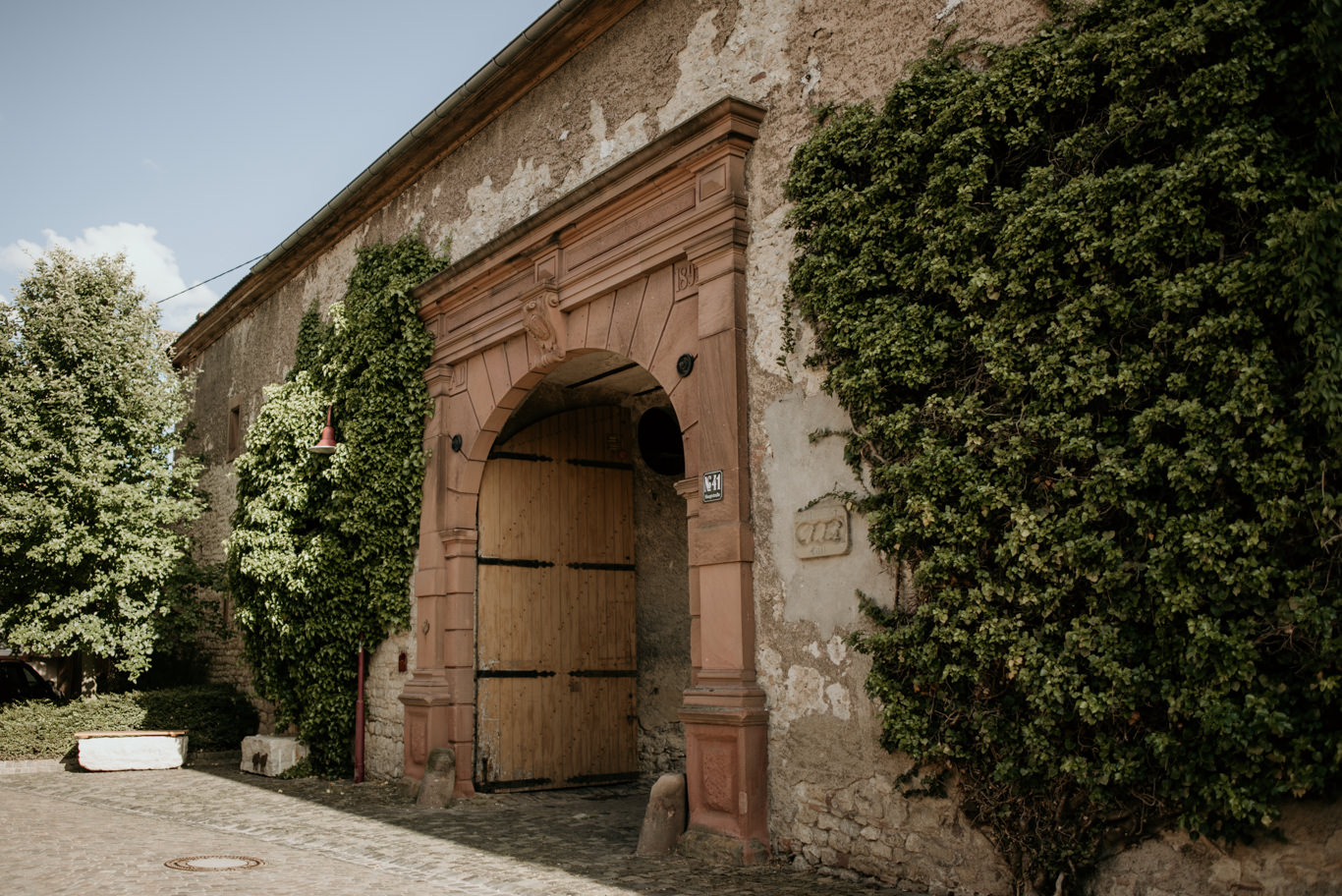 Efeuumranktes Steintor führt in den Innenhof von Schlossgut Lüll