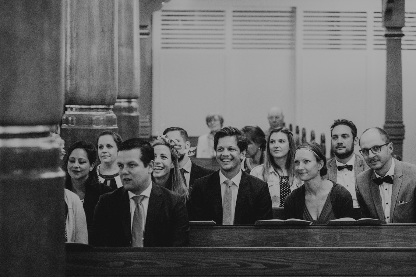 Schwarzweißaufnahme der Hochzeitsgesellschaft in den Kirchenbänken
