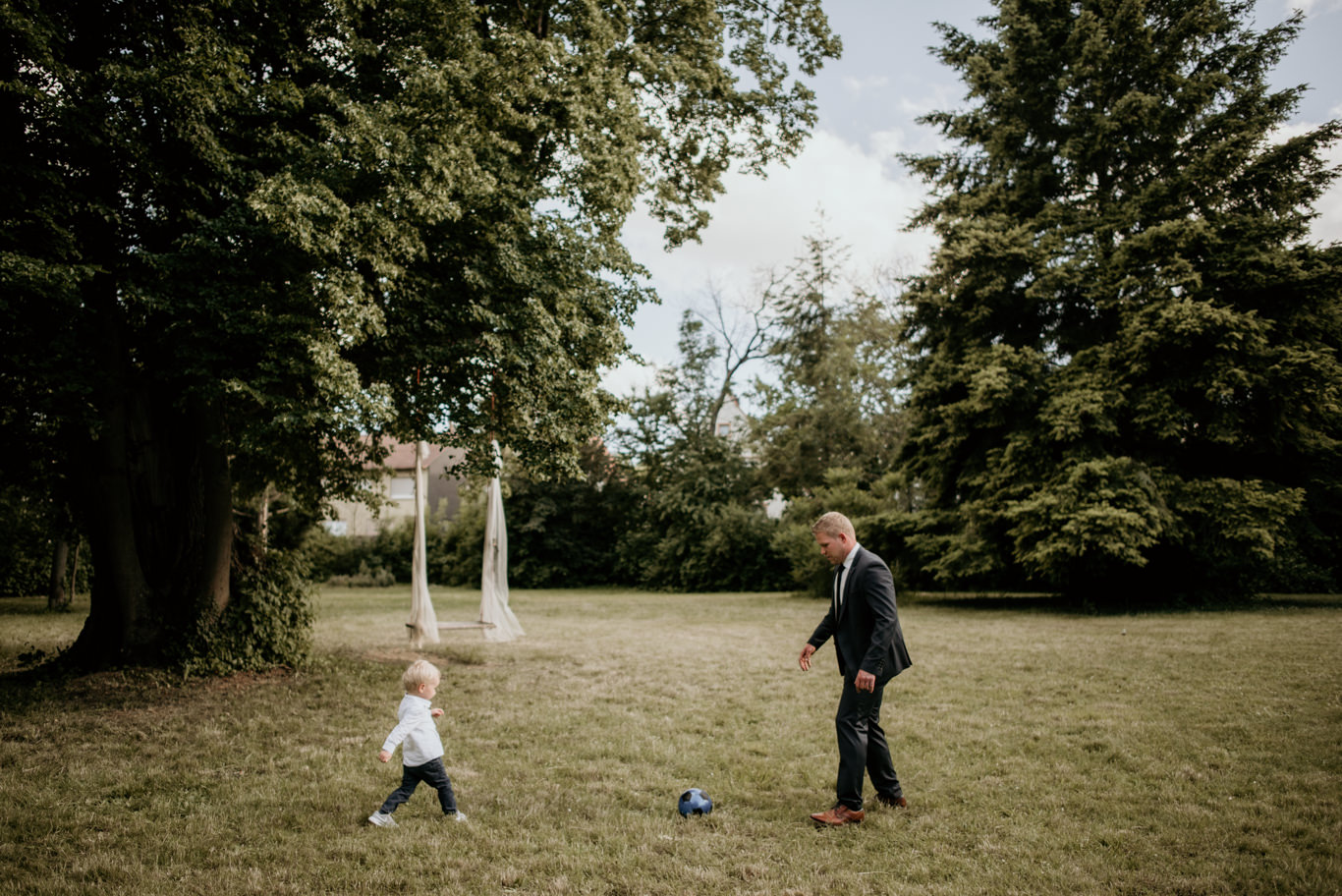 Vater spielt mit seinem Kind Fußball auf der Wiese