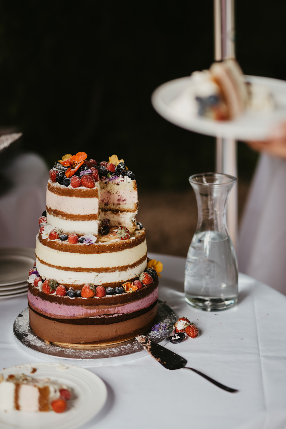 Mehrstöckige Hochzeitstorte mit Beeren steht auf der Kaffeetafel