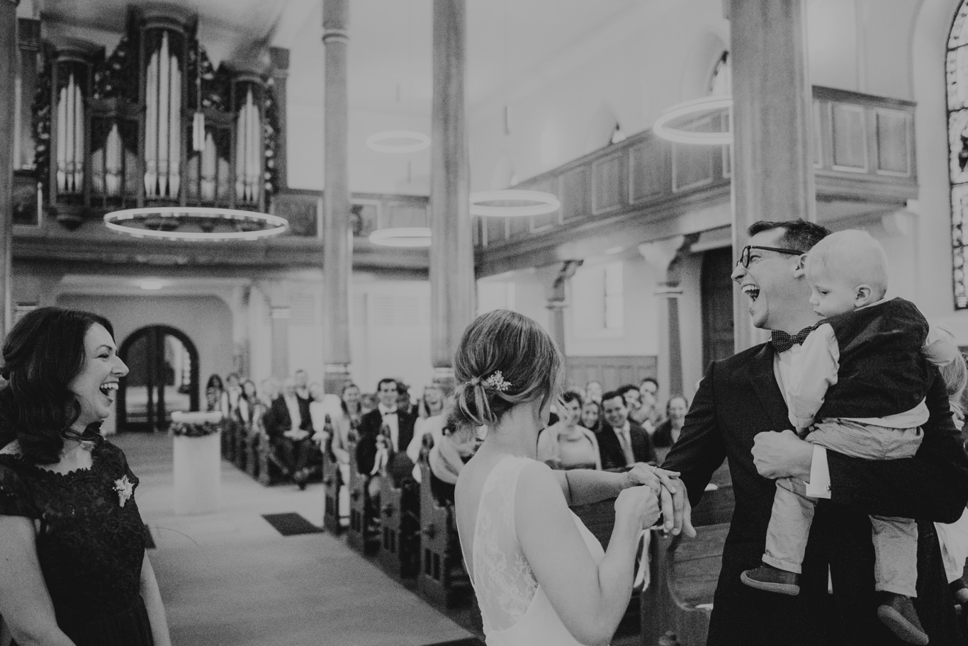 Schwarzweißaufnahme der Gäste, die sich in der Kirche begrüßen