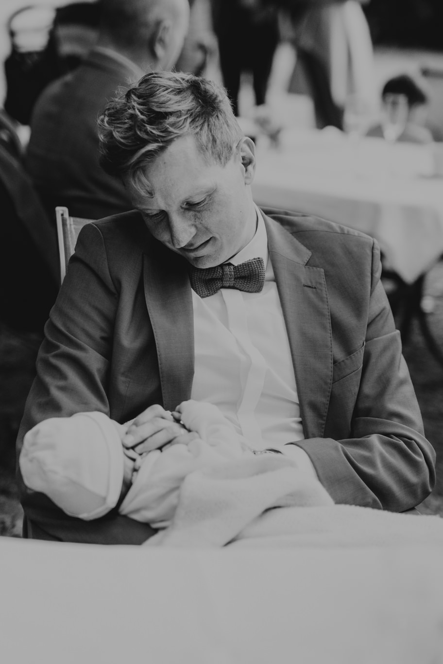Schwarzweißaufnahme eines Mannes, der ein Baby im Arm hält
