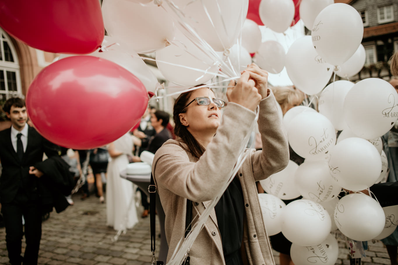 Frau bindet bunte Luftballons für die Hochzeitsfeier zusammen