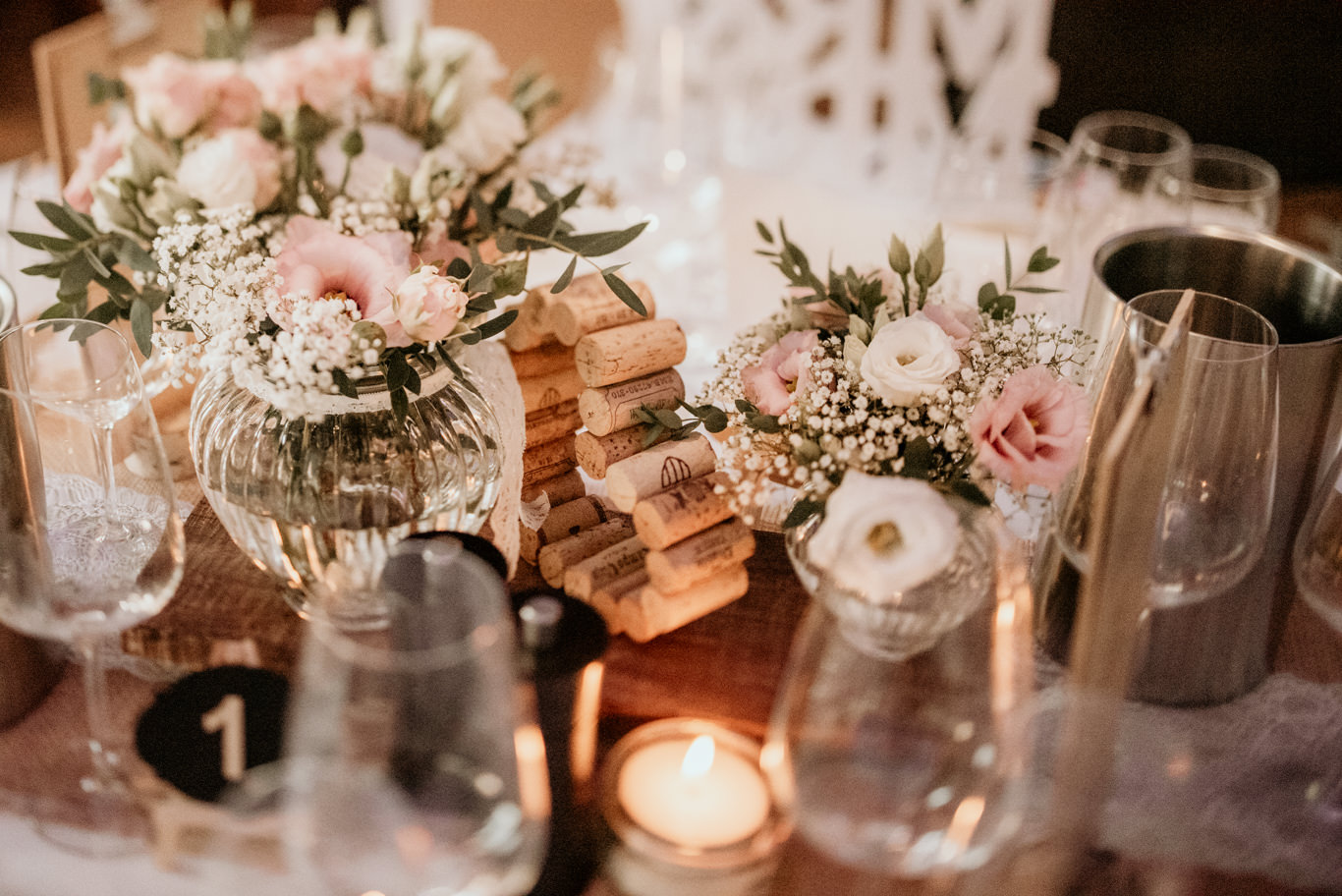 Tischdekoration mit Blumenstrauß, Kerzen und Namensschild aus Holzklötzen