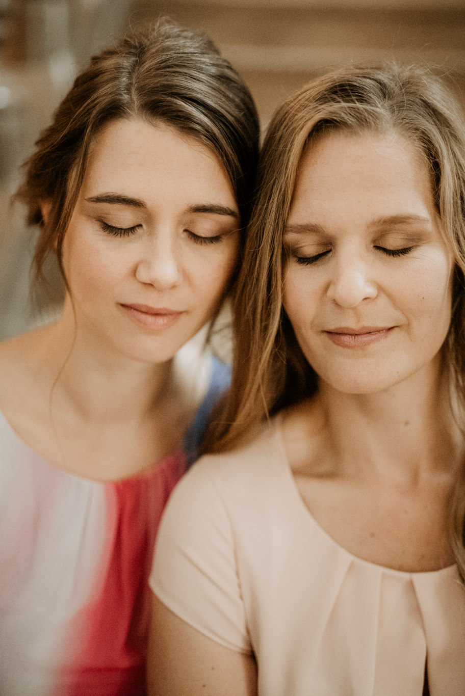 Zwei Frauen lehnen sich lächelnd aneinander