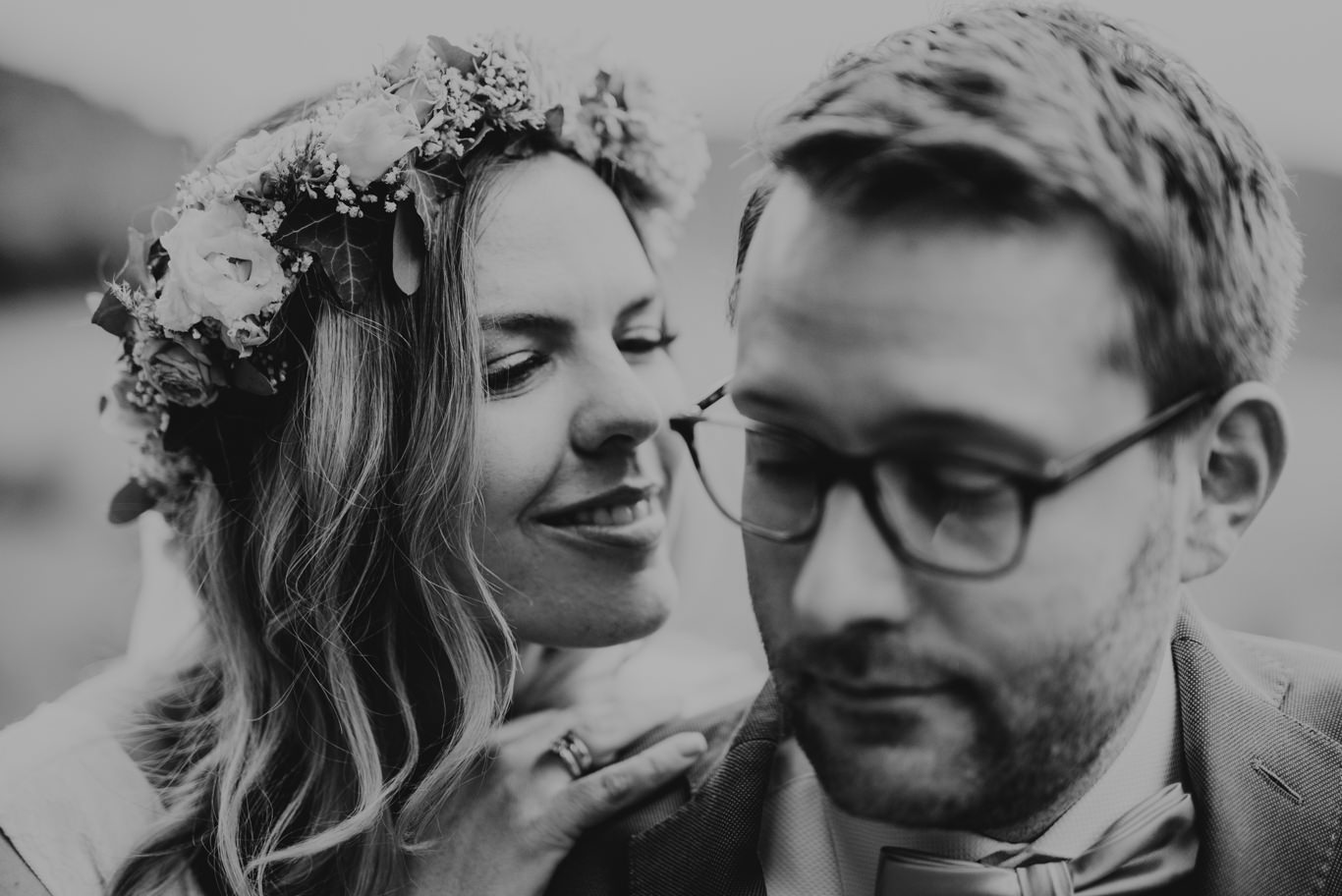 Braut mit Blumenkranz lehnt lachend an Bräutigam, Schwarzweißaufnahme