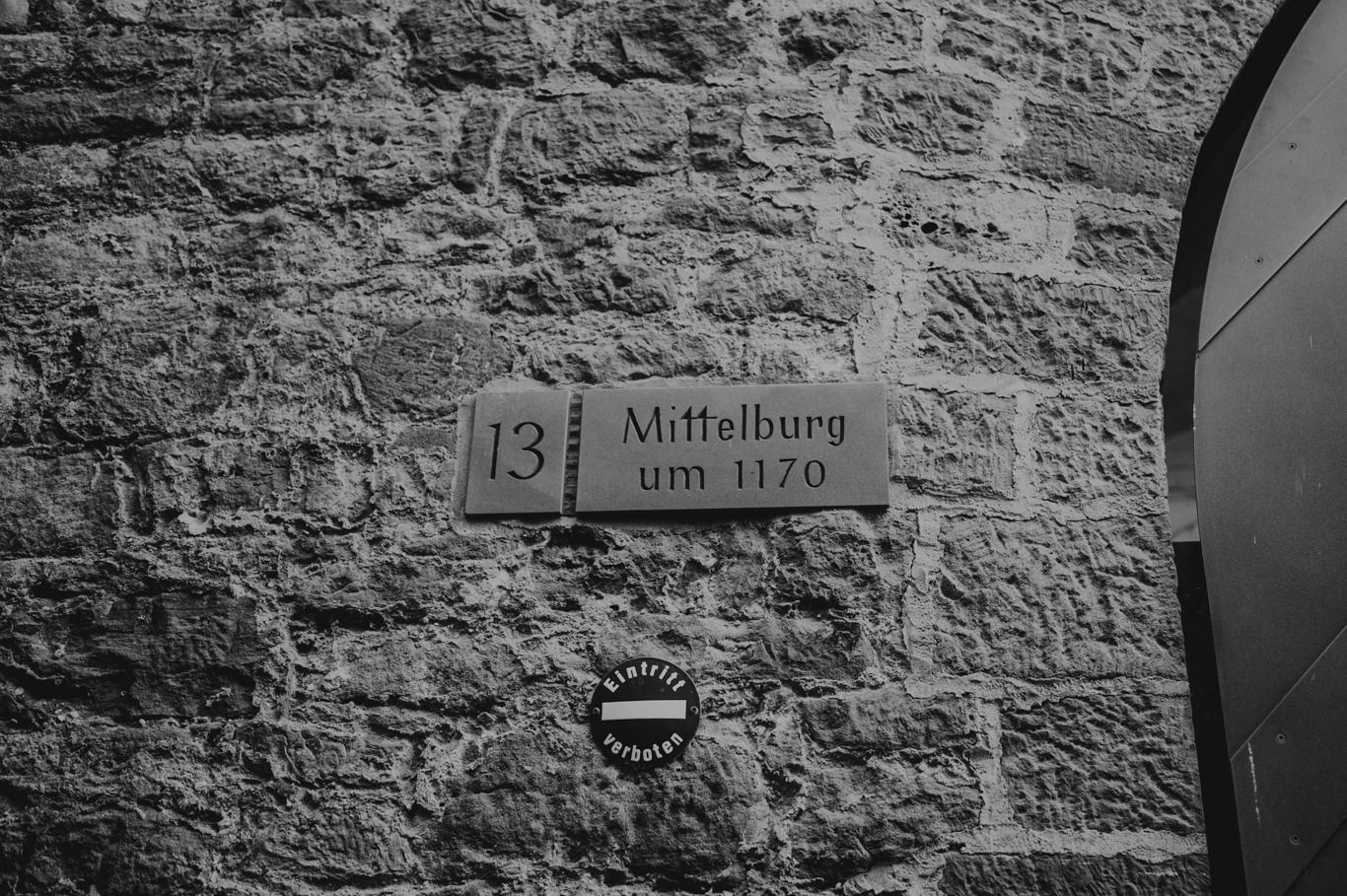 Historisches Schild mit Inschrift Mittelburg an einer Steinmauer, Schwarzweißaufnahme