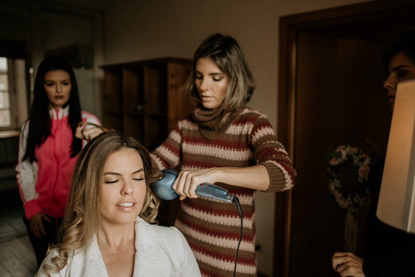 Visagistin föhnt und stylt die Haare der Braut