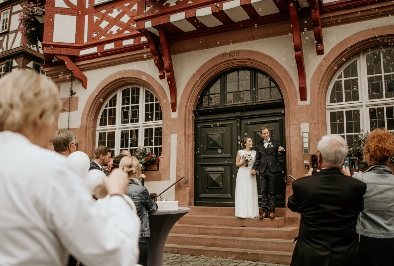 Gäste fotografieren Brautpaar vor Fachwerk-Rathaus in Heppenheim