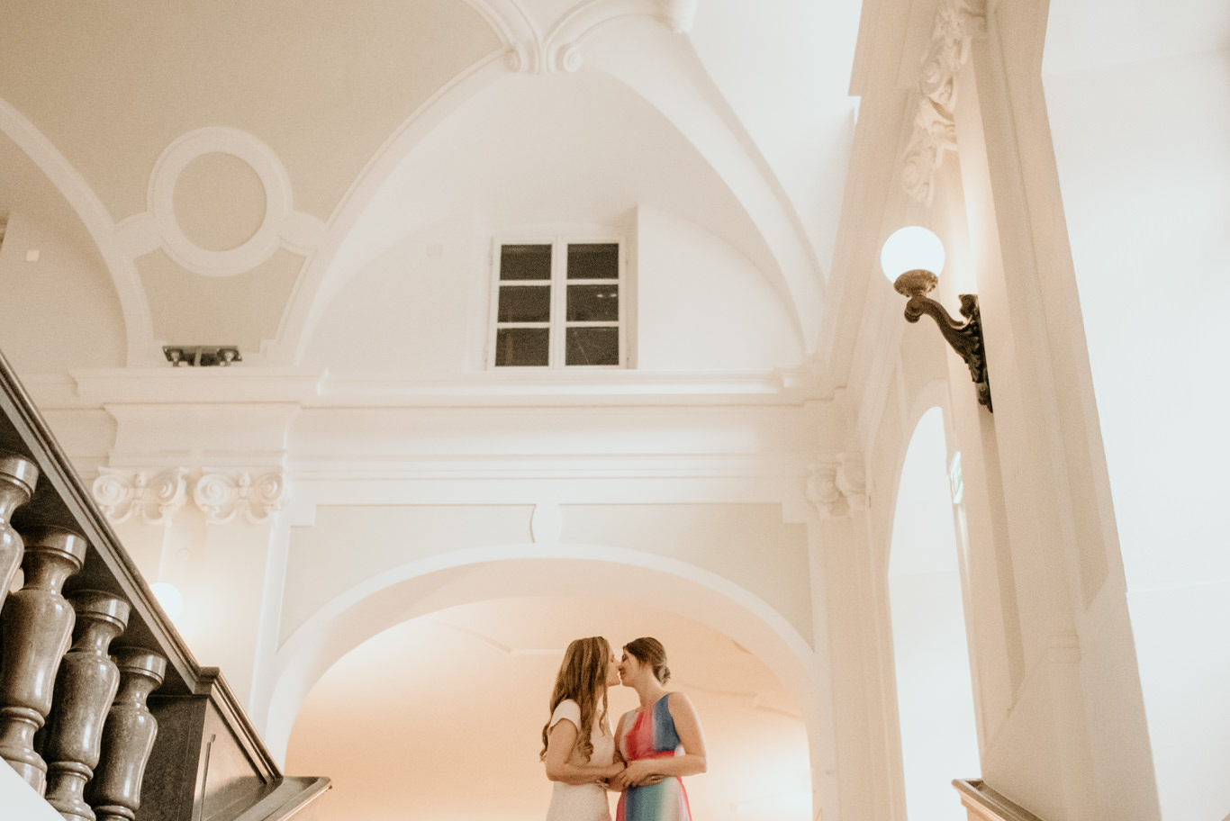 Zwei Bräute umarmen sich auf der Treppe eines historischen Gebäudes in Heidelberg