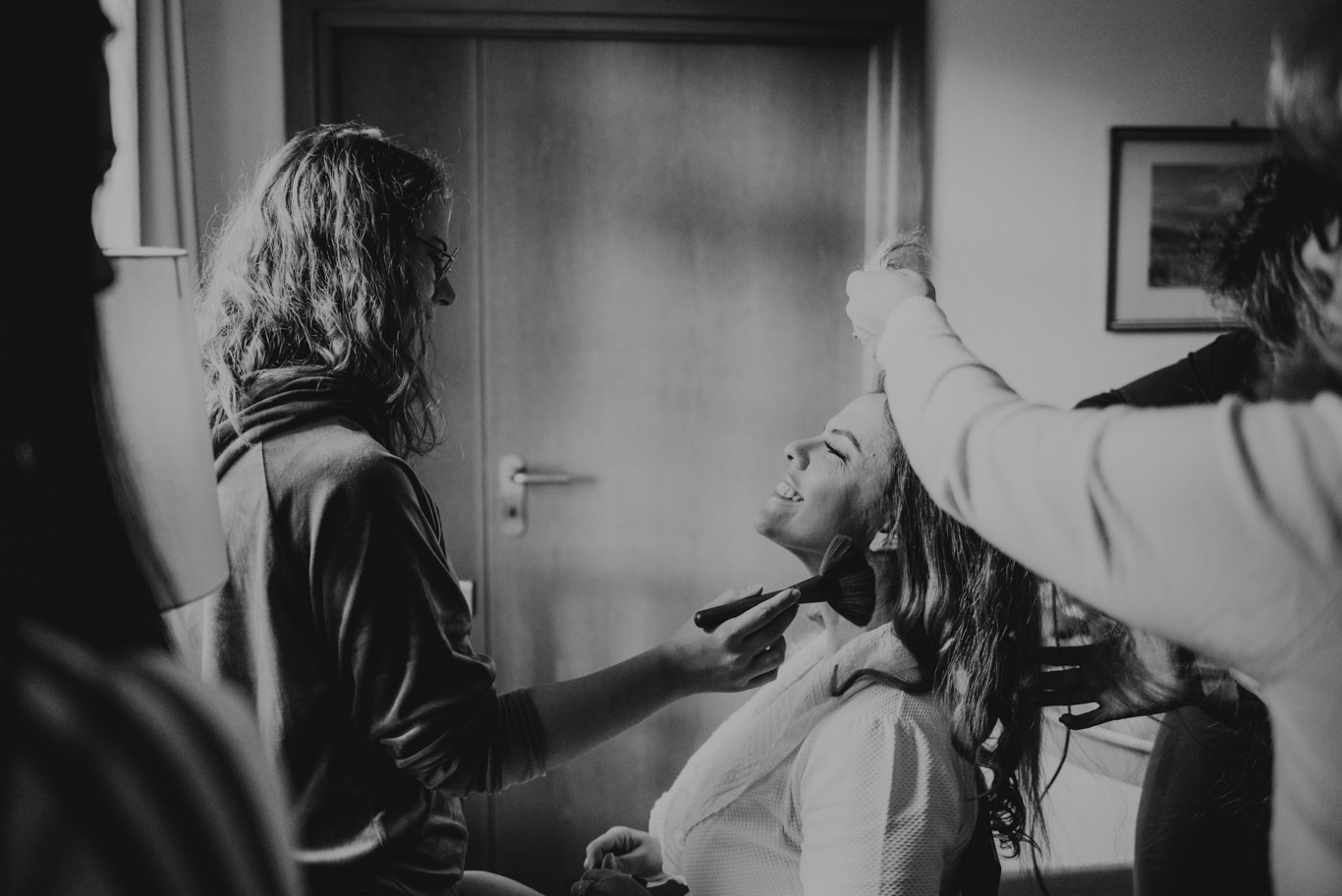 Frisörin steckt der Braut die Haare hoch, Schwarzweißaufnahme