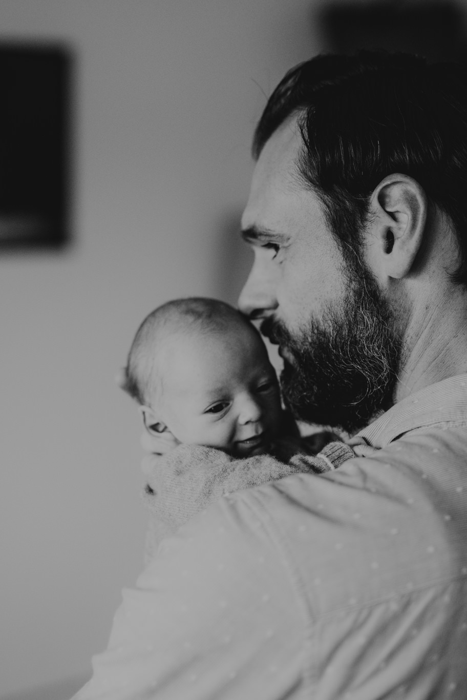 Schwarzweißaufnahme, Vater hält sein Baby im Profil an sich