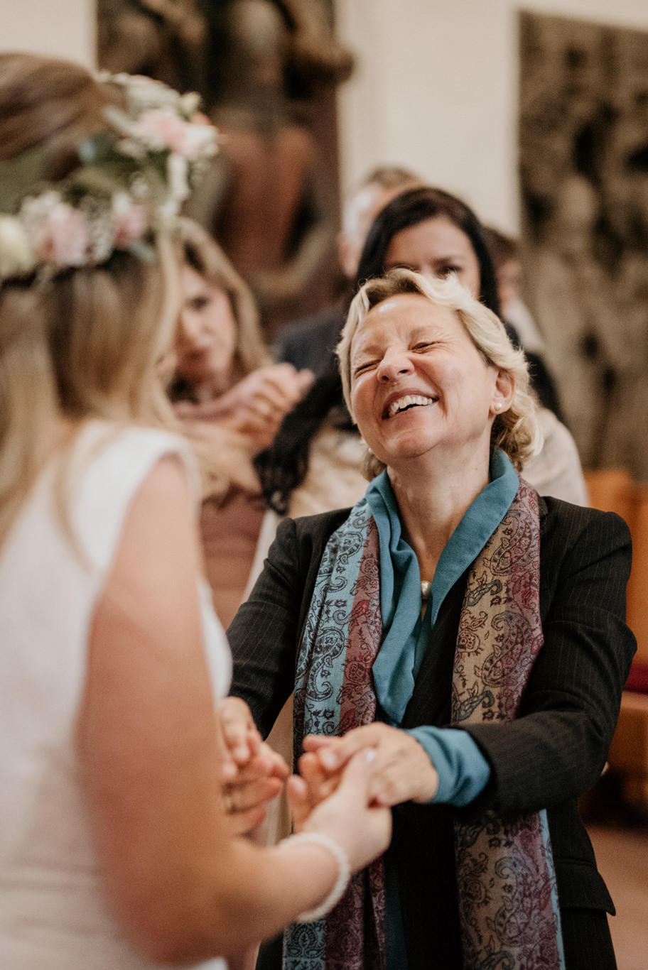 Gäste gratulieren lachend dem frisch verheirateten Paar