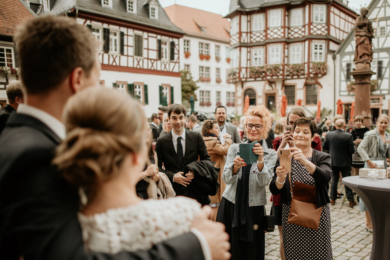 Brautpaar wird von Gästen vor Fachwerkhäusern in Heppenheim begrüßt